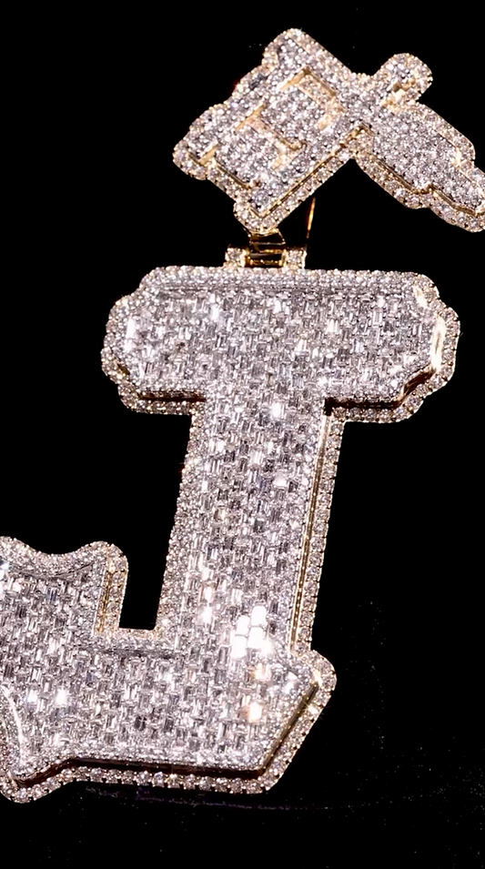 Side view of the J pendant, showcasing its bold design with round and baguette-cut colorless diamonds