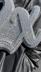 Angled view of the '2X' letter pendant, showcasing its dazzling stones and bold 925 sterling silver design