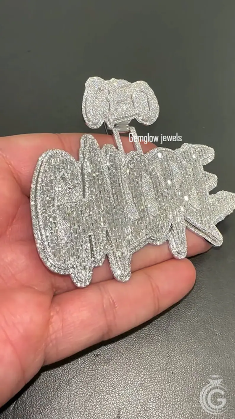 Angled shot of personalized diamond name pendant, silver iced letters in oversized hip hop design