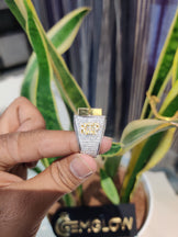 Hand holding a small diamond-encrusted object with blurred background