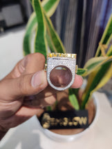 Gold and silver ring held by a hand with a blurred background
