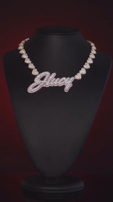Video of custom letter pendant with heart-shaped chain, showcasing iced-out design and full 360° view